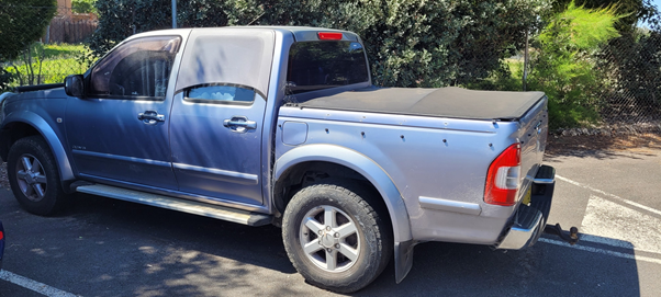 Side view of abandoned silver Holden utility