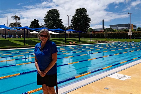 Woman standing in front of outdoor pool