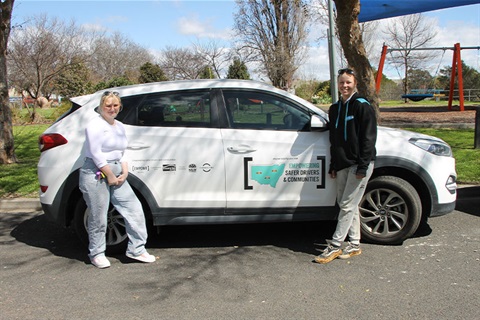 Two participants from the Empower Mobility program stand in front of a car