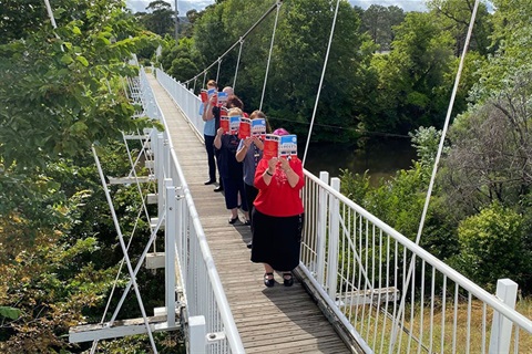 Library staff reading on Queanbeyan suspension bridge