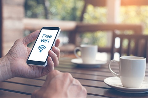 Man holding phone with Free WiFI symbol showing