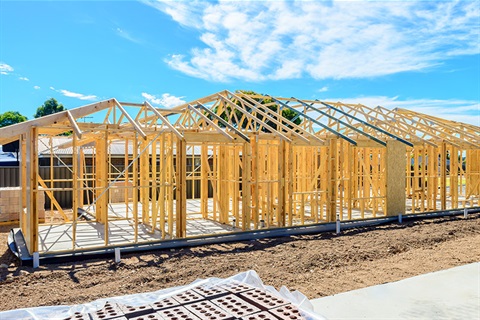 Photo of house being constructed, with wooden frames showing