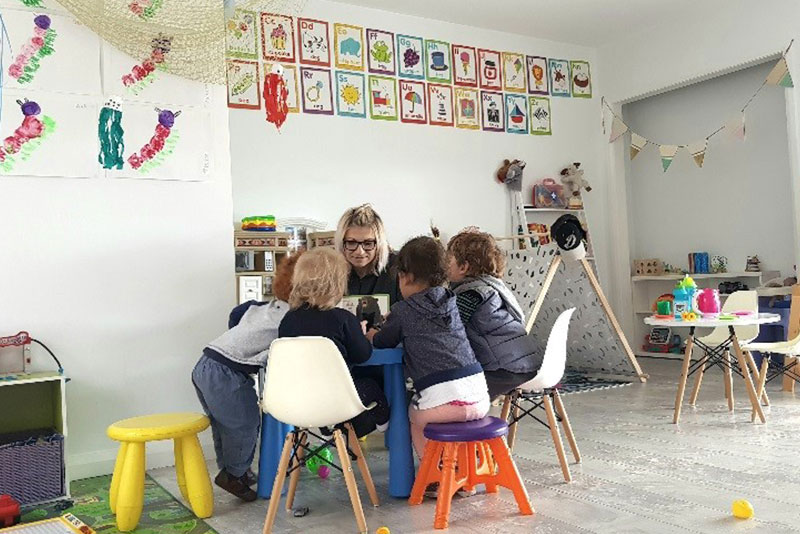 Educator with children at table doing craft activities