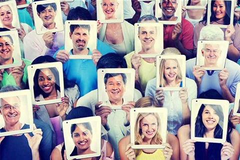 Group of people holding up tablets with faces in screen