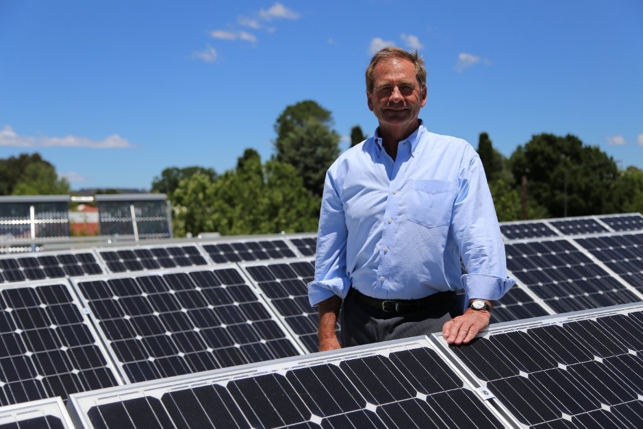 Former Mayor Tim Overall with solar panels on rooftop at The Q