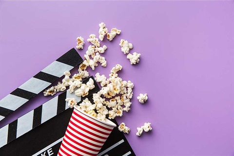 Movie clapper board and bucket of popcorn
