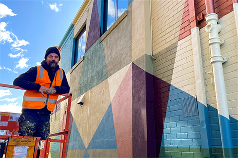 Al Stark in Blacksmiths Lane on scissor lift next to mural