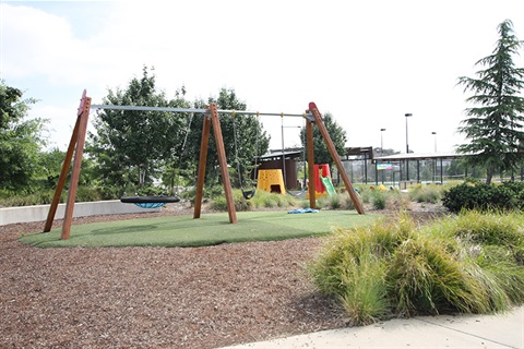 Beltana Park Googong showing playground equipment - a nest swing, swings, slides and spinners